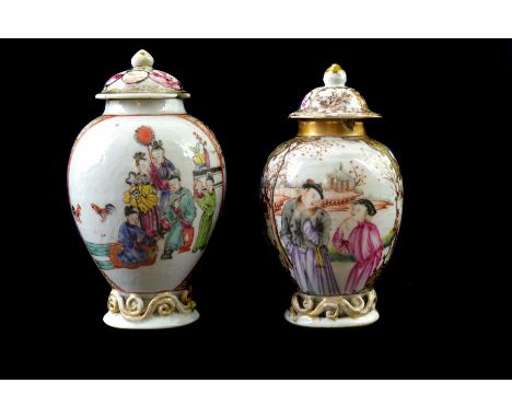 Two Chinese export porcelain tea canisters and covers, of ovoid form on openwork scroll feet, polychrome painted with figures