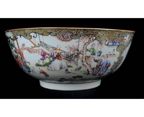 An exceptionally large Chinese export porcelain punch bowl, finely painted with figures in garden settings within scrolled mi