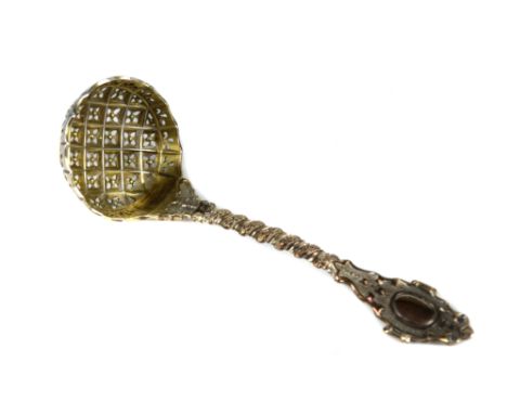 A Victorian silver sugar sifter ladle, ornately cast and pierced with quatrefoil trellis work bowl, the bowl gilded, London 1