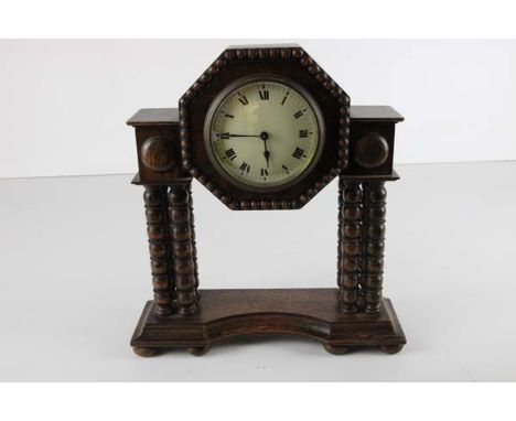 An early 20th Century oak cased mantle clock on bobbin turned supports - overall dimensions in cm are 29 high x 26 wide