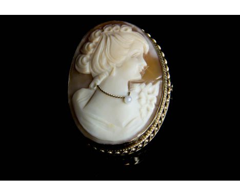 A vintage 9ct gold and shell cameo brooch, carved with a young lady with pearl set necklace, in a beaded gold mount with susp