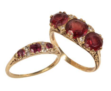 A THREE STONE GARNET AND DIAMOND RING the three round-cut garnets, divided with four round-cut diamonds, on an 18ct yellow go