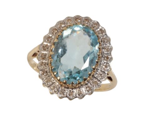 A GEMSTONE AND DIAMOND RING the pale blue gemstone, within a border of illusion-set diamonds, on a yellow gold shank, stamped