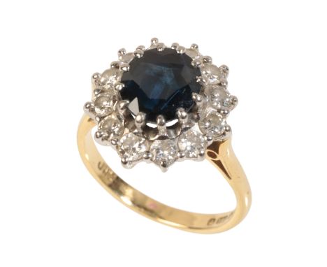 A SAPPHIRE AND DIAMOND CLUSTER RING the oval-cut sapphire within a border of twelve brilliant-cut diamonds, on an 18ct yellow