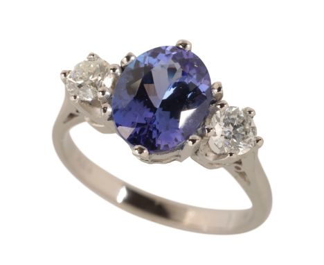 A TANZANITE AND DIAMOND RING the oval-cut tanzanite c.2.80ct, flanked either side with a brilliant-cut diamond, on a Platinum