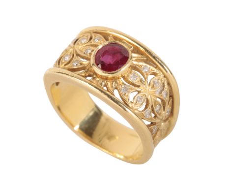 A RUBY AND DIAMOND RING the openwork floral setting set with round-cut diamonds, and an oval-cut ruby, on an engraved gold sh