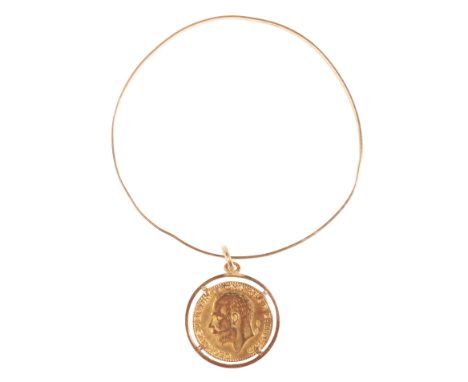 AN ENGRAVED GOLD BANGLE stamped "750", with attached mounted re cast sovereign dated 1911, approx 10.3 grams total weight