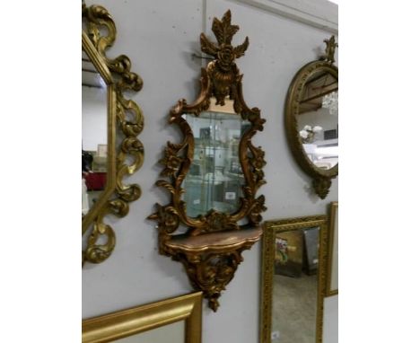 An ornate gilt framed mirror with shelf, approximately 106 x 48cm