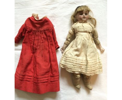 A small 19th century doll with kid leather and cotton body, jointed legs and stitch jointed knees and arms, bisque head and c