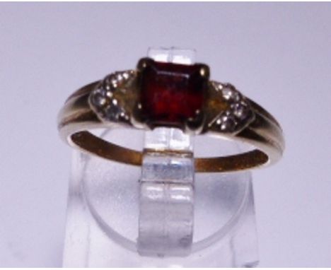 YELLOW METAL RING. Yellow metal and garnet ring, size N/O