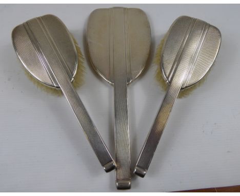 A Silver Dressing Table Set, comprising mirror and two hair brushes, Birmingham hallmark, dated 1937, mm Mappin & Webb.