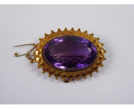 An Edwardian 15 ct Gold and Amethyst Brooch. The amethyst set in a disc and beaded mount, the stone approx 30 x 20 mm, approx