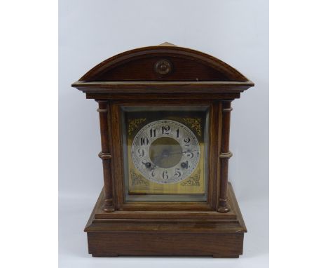 An Oak Cased Mantle Clock, the clock having silvered face and numbered dial.