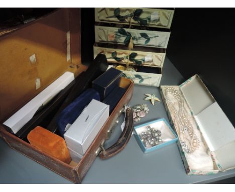 A huge variety of vintage costume jewellery in a small case and little sets of drawers.