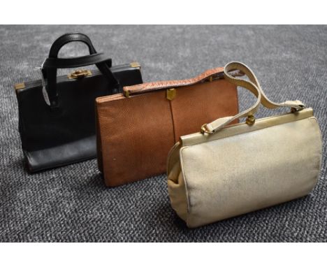 Three vintage handbags having clasp fasteners, one cream, one black and one tan. All in good order.
Good condition, slight ag
