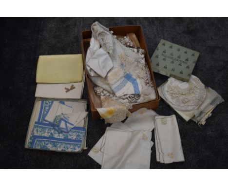 An array of antique and vintage table linen with a variety of techniques used, some in original boxes.