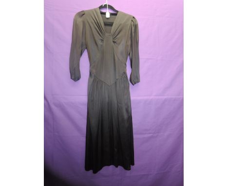 A vintage early 1940s black dress in a satin crepe type fabric, having half belt to waist, gathered neckline and side press s