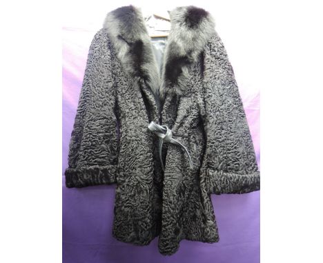 A vintage Astrakhan coat having large fur collar, pockets to sides and belted waist. David Jackson ltd, Eastbourne Worthing. 