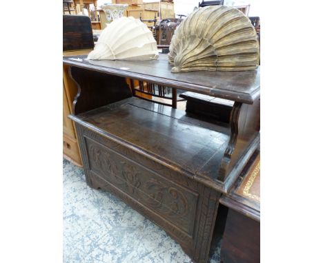 A 20th C. OAK MONKS BENCH WITH THE HINGED TABLE TOP BACK REST ABOVE A COFFER SEAT WITH FOLIATE CARVED FRONT.   W 92cms.