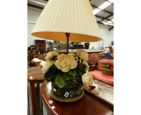 AN UNUSUAL TABLE LAMP WITH FAUX FLOWER AND TOLE BASE.