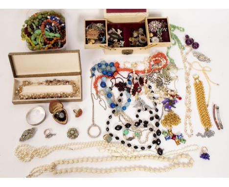 A quantity of costume jewellery including bead necklaces, silver bangle, enamelled brooches etc.