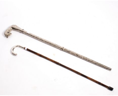 An Edwardian bamboo cane, the plain silver handle London 1901 and a white metal walking stick, the end containing a blade Con