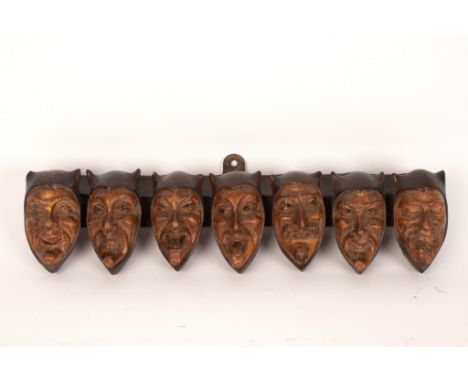 A pipe rack for seven pipes, the supports in the form of jester mask heads, 35cm long