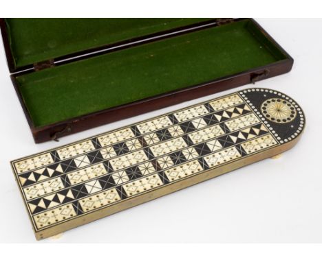 An 19th Century ebony and ivory inlaid cribbage board with brass edge on turned feet, 35.5cm long, in a baize lined mahogany 