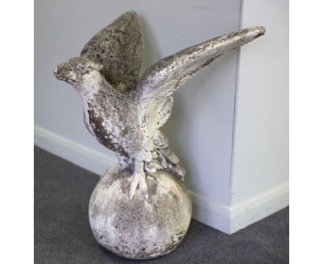 A composition stone gate post or roof finial of an eagle on an orb, 73cm high
