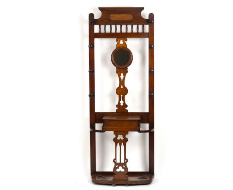 An Edwardian mahogany hall stand with central circular mirror set in pierced splat, shelf with lidded compartment and stick s