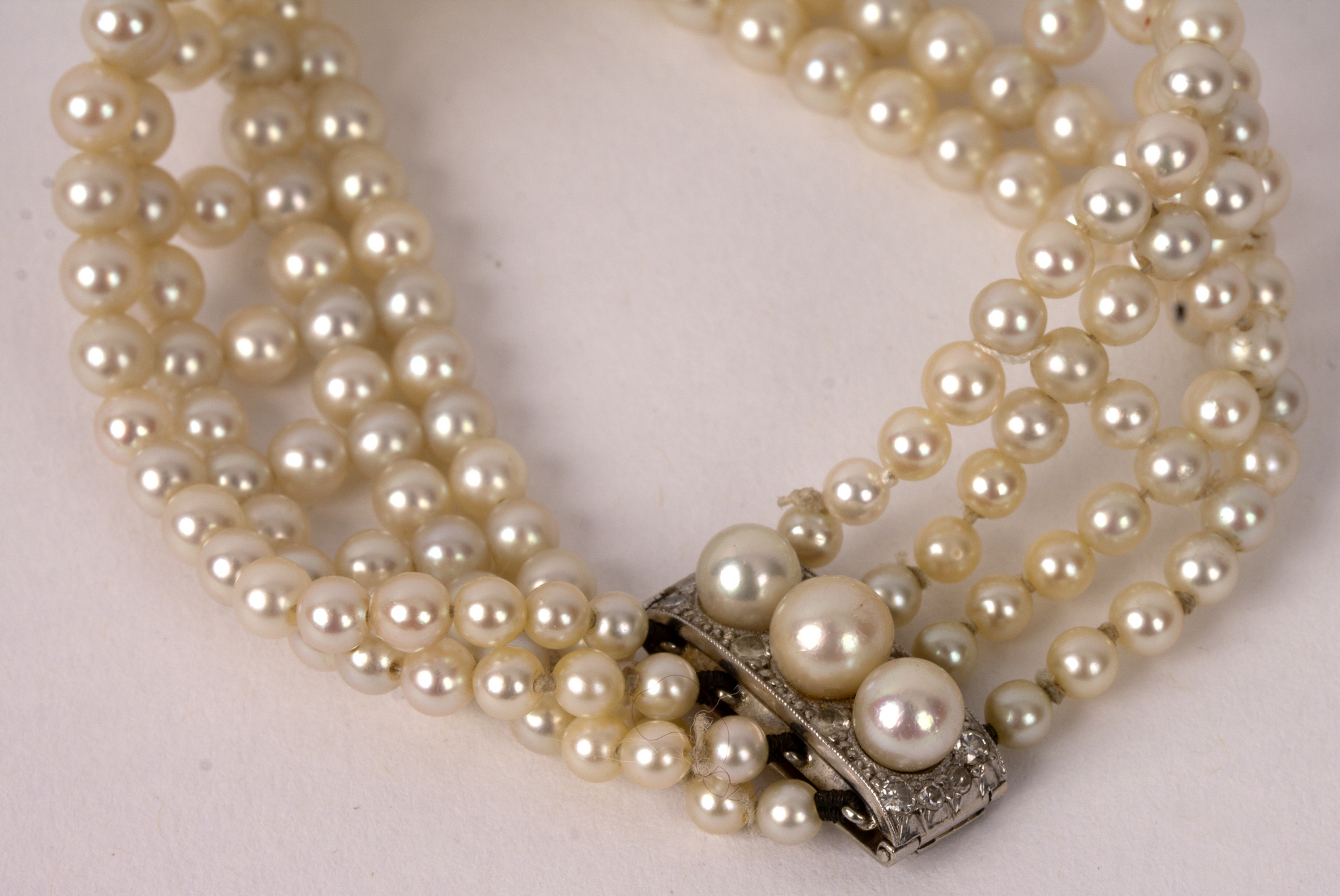 A four-row pearl bracelet with pearl and diamond clasp, 19.5cm long