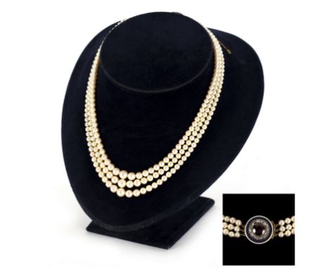 A three-row cultured pearl necklace joined by a garnet, diamond and enamel cluster clasp/see illustration