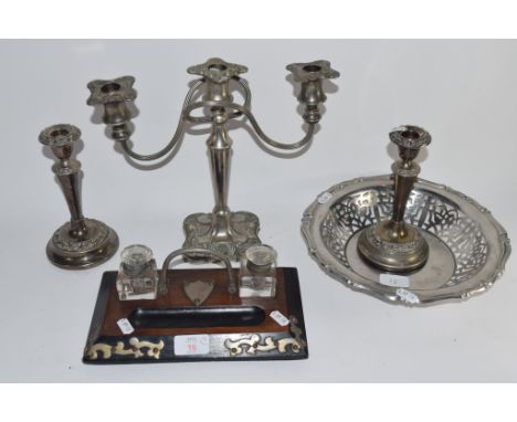 DESK SET COMPRISING TWO GLASS INKWELLS SET INTO WOODEN MOUNTS WITH METAL DECORATION, PLUS A PAIR OF PLATED CANDLESTICKS, CAND