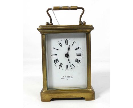 An early 20th century lacquered brass carriage clock, the white dial signed by the trailer WE Grey of Oxford Street