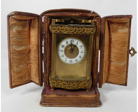 A late 19th century French lacquered brass carriage clock of shaped outline, having an enamel chapter ring with numeral marke