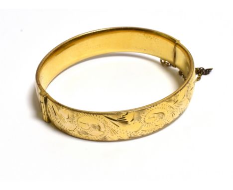 ROLLED GOLD ENGRAVED BANGLE 12.6mm wide, scroll and bright cut engraved front, plain back with concealed tongue clasp and saf