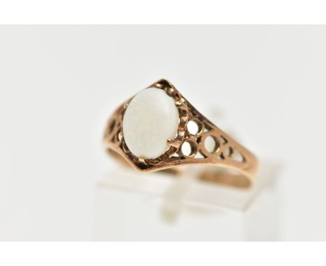 A 9CT GOLD OPAL RING, designed with an oval opal cabochon in a six claw setting, openwork detailed shoulders leading onto a p