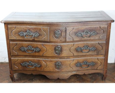A late 18th century North European oak commode, of bombe form, with two short and two long drawers on short cabriole legs, 80