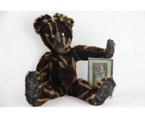 An English teddy bear, possibly Chiltern, with striped 'tiger' effect fur and black velvet pads with articulated joints, 60cm