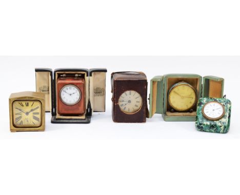 A collection of five bedside/traveling clocks, circa 1920s-50s, having manual wind movements, three with original travel case