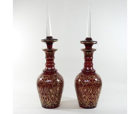 A pair of unusually large early 20th century continental ruby glass jars and stoppers, each with all over gilt decoration, ha