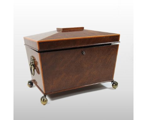 A Regency mahogany and boxwood strung tea caddy, of sarcophagus shape, with a hinged lid, fitted with a pair of lidded compar