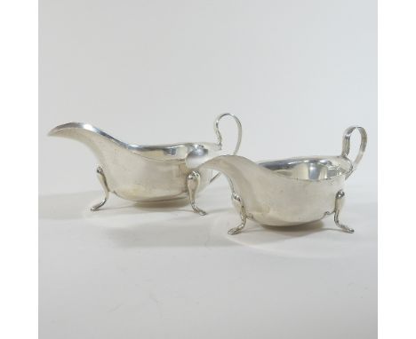 An early 20th century silver sauce boat, of helmet shape, London 1932, 152g, 17cm long, together with a matching cream jug, s