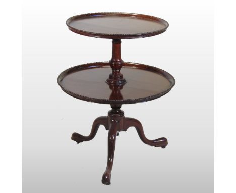 A George III style mahogany two tier dumb waiter, having two dished graduated tiers, each with a beaded edge, on a tripod bas