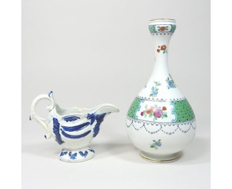 An 18th century Staffordshire blue and white pearlware jug, c1770, of scrolled helmet shape, on a pedestal foot, 9cm high, to