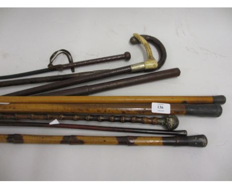 Group of nine various swagger sticks and riding crops together with a leather and brass whip rack