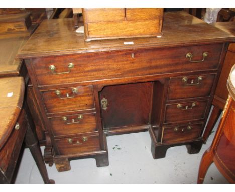 George III mahogany kneehole desk, the moulded top above seven drawers surrounding a central kneehole cupboard raised on brac