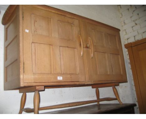 Mid 20th Century Ercol elm sideboard with two panel doors raised on splay supports