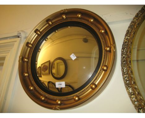 Circular gilded composition ball pattern convex mirror, an early 20th Century teak and brass mounted desk thermometer and an 