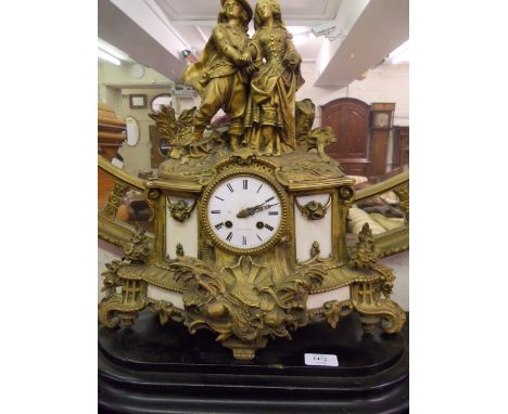 19th Century French gilt metal mantel clock mounted with a figure of a 17th Century Cavalier and a maiden above a circular en